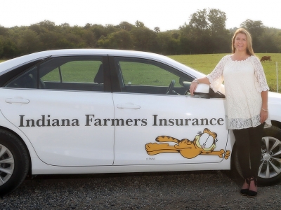 Associates standing next to Indiana Farmers Insurance car